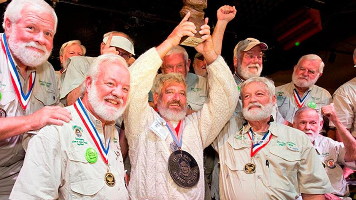 A past Hemingway Days lookalike contest raises his championship trophy.