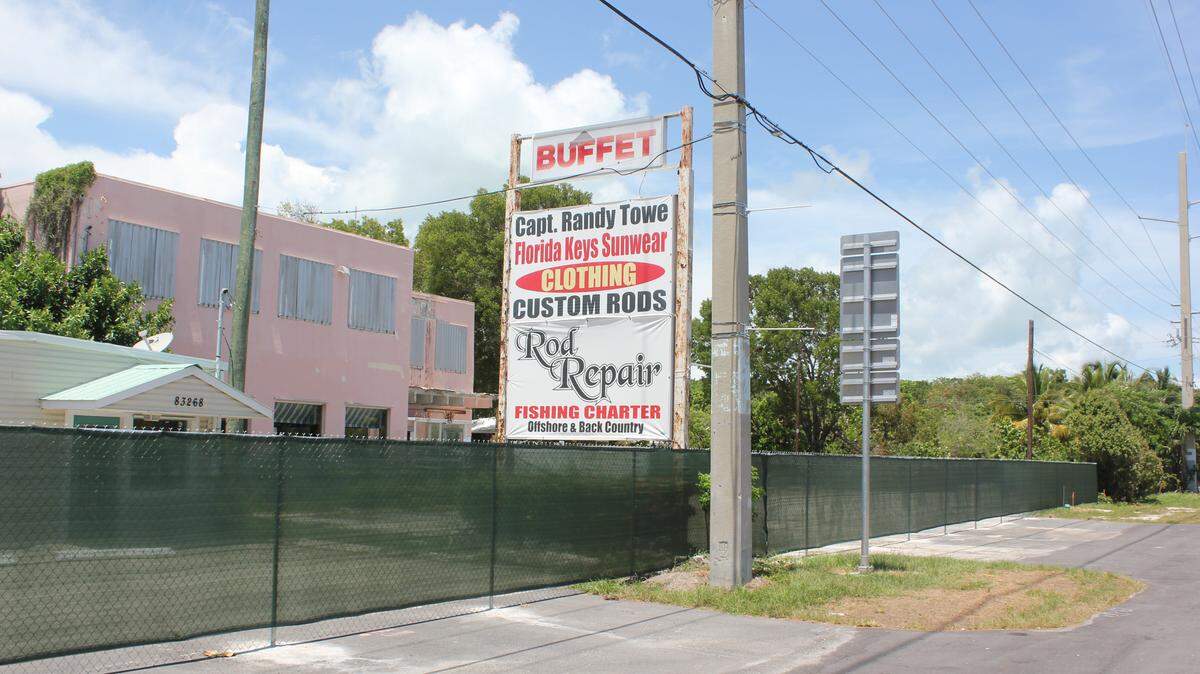 A new fence cordons off the proposed site for a new Publix store in Islamorada. No work to demolish existing buildings has been approved yet.