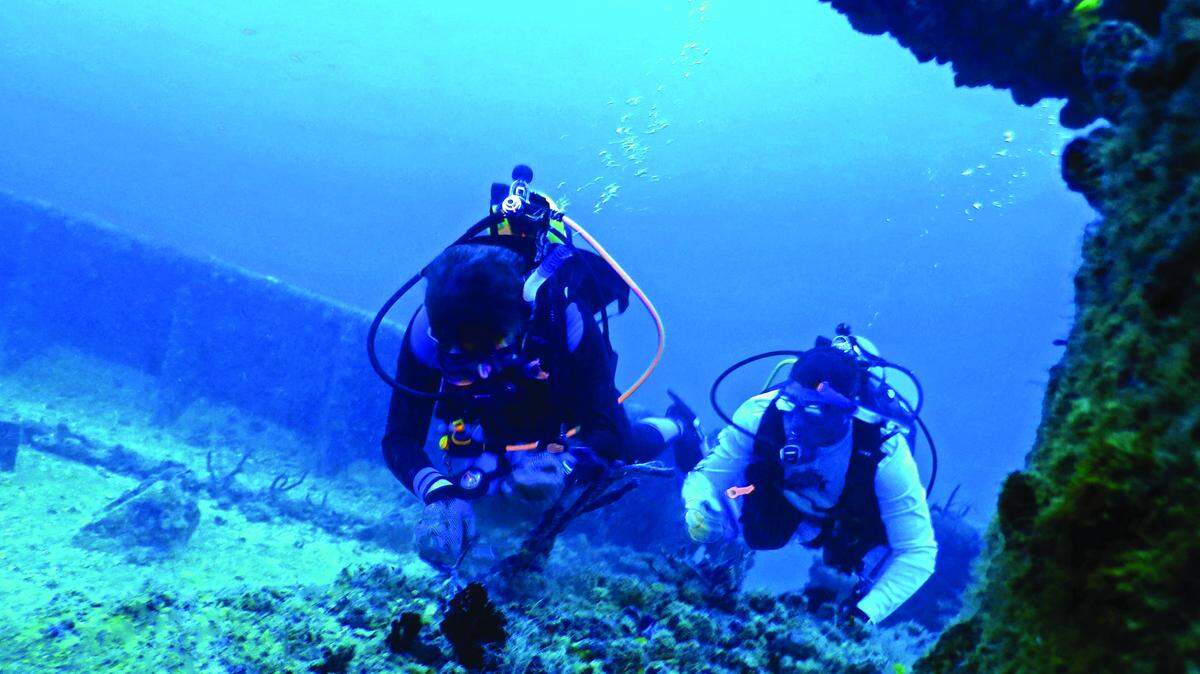 Bob Eicholtz and Chris Agard remove fishing line from the Thunderbolt, an intentionally-sunken vessel located offshore south of Marathon.
