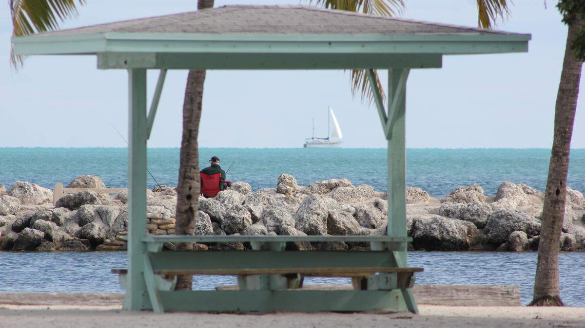 A man sits on a jetty at Harry Harris Park in Tavernier in the Florida Keys in this undated photo. A group of people participating in a community clean-up found a brick of cocaine at the park Saturday, Jan. 28, 2023.