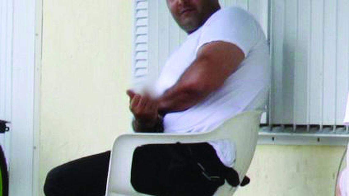 Jarvis Nelson Osorio flips his middle finger at a reporter on July 16 while federal agents raid his Outbreak Ordnance gun shop he owns with former county administrator Tom Willis on Big Pine Key. Federal prosecutors say Osorio bought an M-10 submachine gun in September that is now missing.