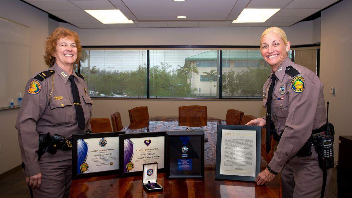 Florida Highway Patrol Lt. Kathleen McKinney and Trooper Christine Gracey stand by medals Gracey earned for her role in apprehending a domestic violence suspect who engaged in a shootout with police in January. McKinney recommended Gracey for the FHP's highest honor, the Medal of Valor.