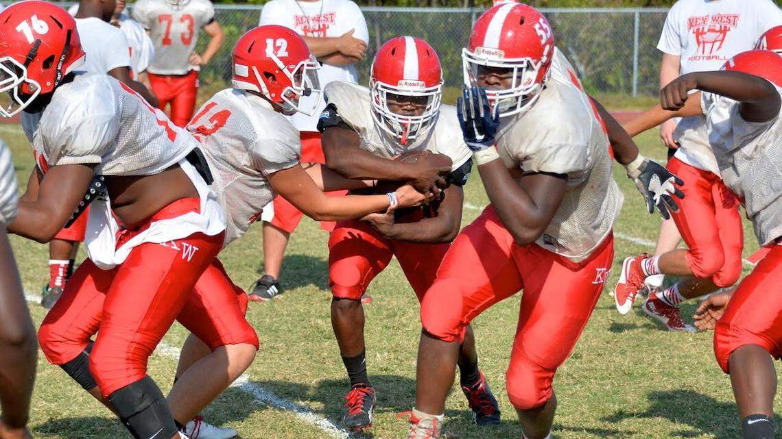 Conch lineman Nash Delice blocks as quarterback Carson Hughes hands off to running back Jodel Deralus during spring practice this week.