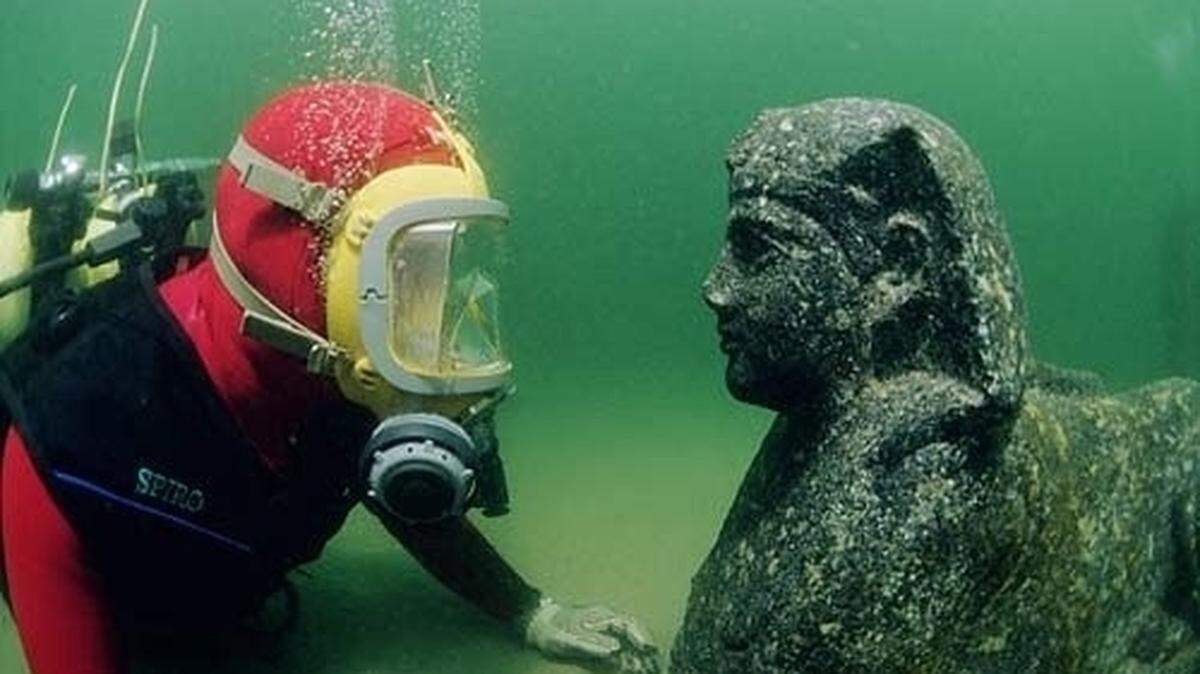 Underwater archaeologist Eric Smith with a sphinx carving he discovered at a 'sunken palace.' (Photo by Jerome delaFosse, provided by the Franck Goddio/ Hilti Family Trust)