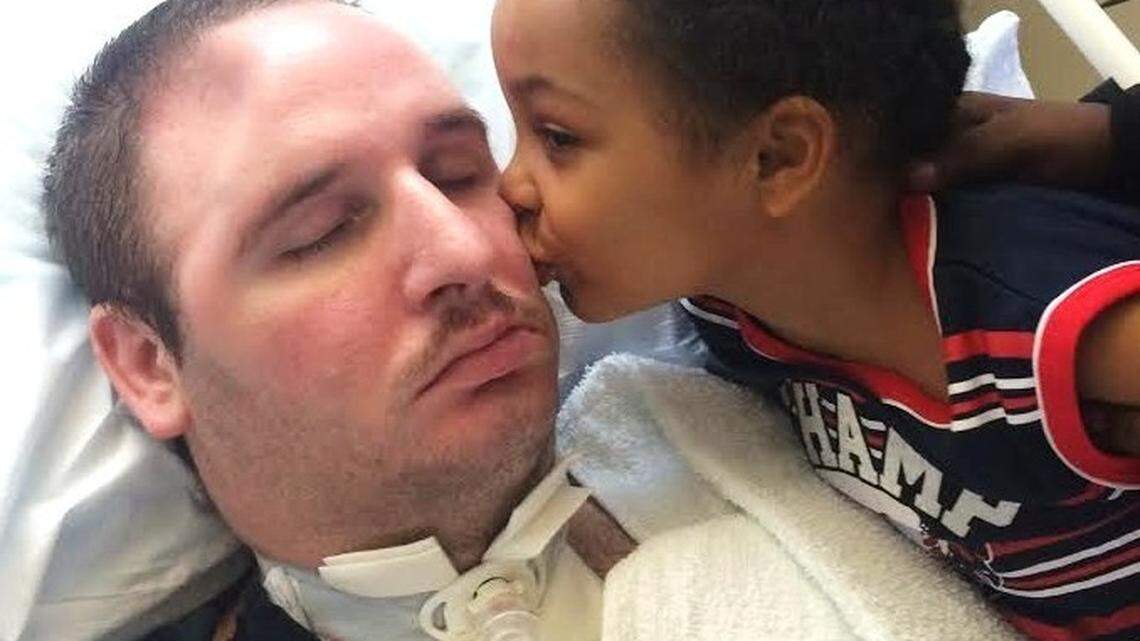 Matthew Murphy's son Kaeden kisses his father, who remains in a Miami long-term care facility.