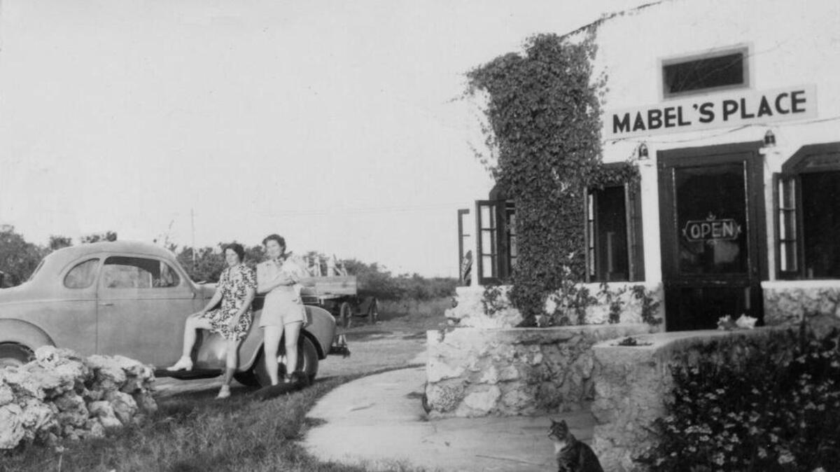 Two women wait outside of Mabel’s Place, which used to be on County Road 905.