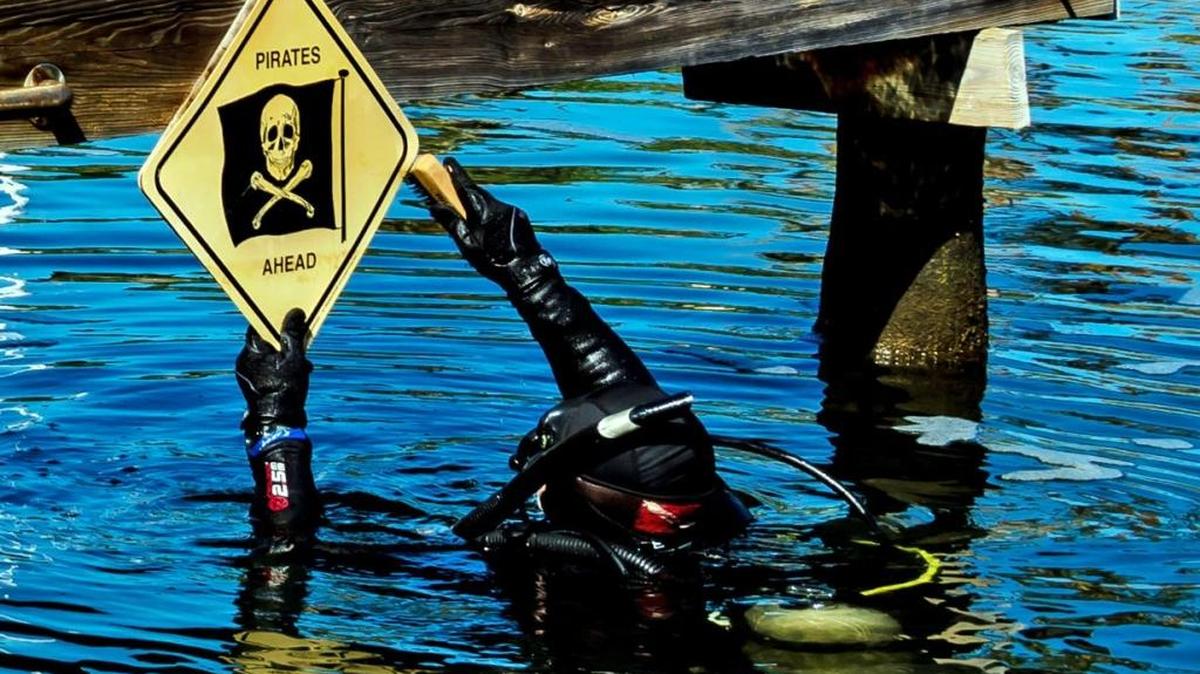 Jules Undersea Lodge dive instructor Dan Blezio fixes a sign in the park’s lagoon. Parts of the property were badly damaged during Hurricane Irma.