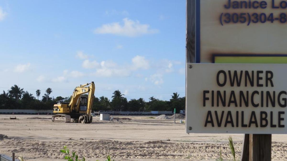 A company sign and an excavator known as a track hoe mark the site of a planned development at the entrance to Key Haven off U.S. 1. Gated homes start at $599,000.