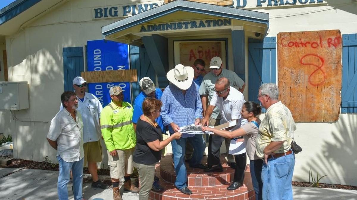 County officials tour the closed Big Pine Key Road Prison’s boarded-up administration office.