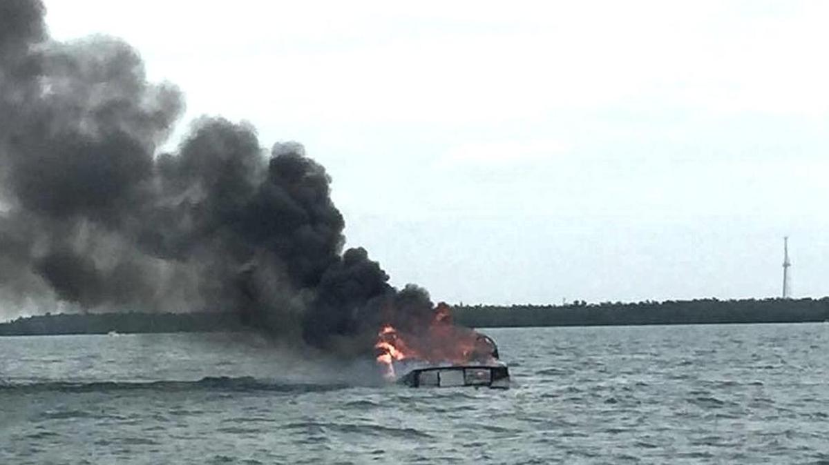 A 1961 Coastwise fishing boat smolders in the water off Boot Key in Marathon Monday morning.