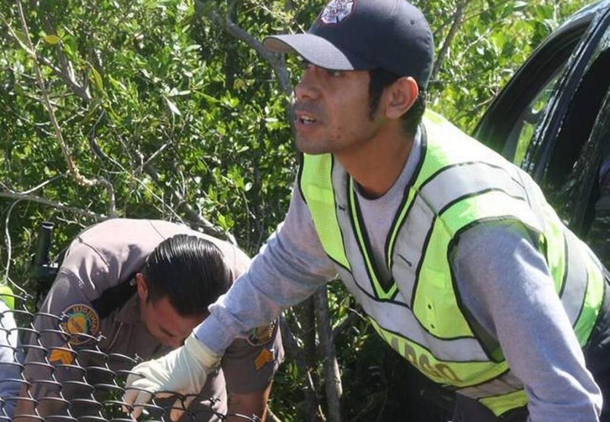 Leonardo Moreno, a Key Largo Volunteer Fire Department firefighter, helps Florida Highway Patrol Sgt. Pedro Reinoso prepare a man suffering serious medical issues to board an ambulance on Aug. 5, 2015, on the 18 Mile Stretch of U.S. 1.