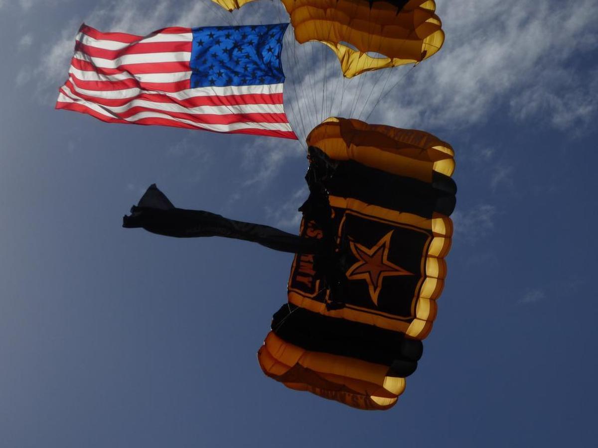 A U.S. Army Golden Knights parachute team member comes in for a landing towing an American flag at Homestead Air Reserve Base on Feb. 23, 2017.