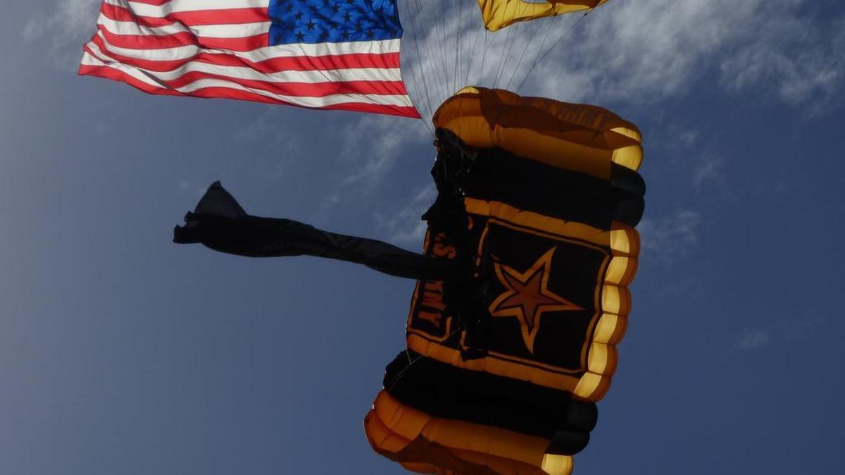 A U.S. Army Golden Knights parachute team member comes in for a landing towing an American flag at Homestead Air Reserve Base on Feb. 23, 2017.