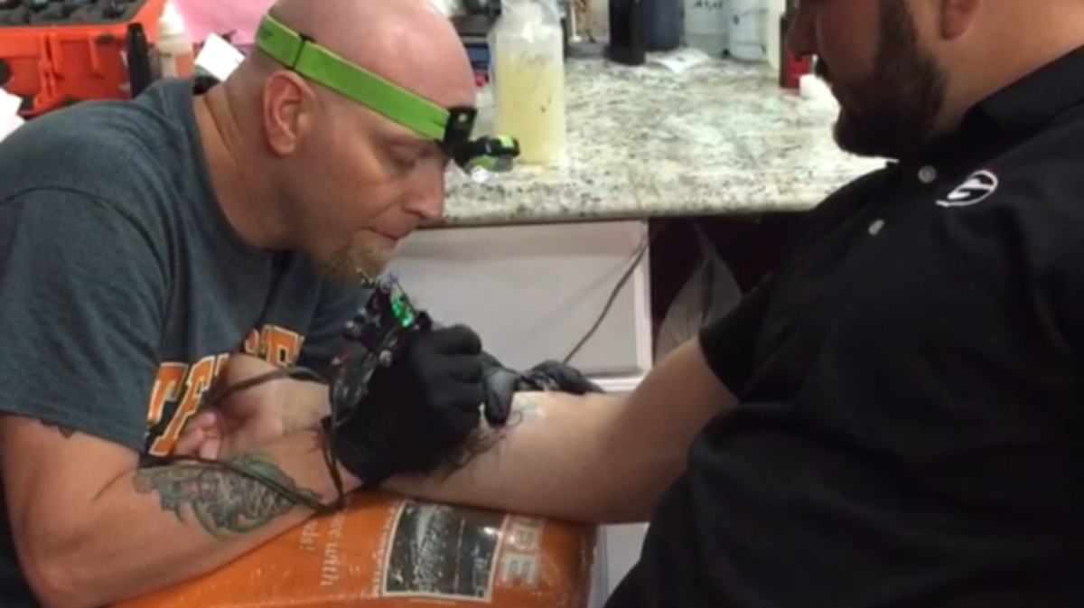Jason Covington works on a tattoo in this photo.