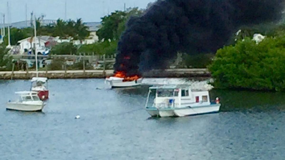 The flaming boat emits billowing smoke.