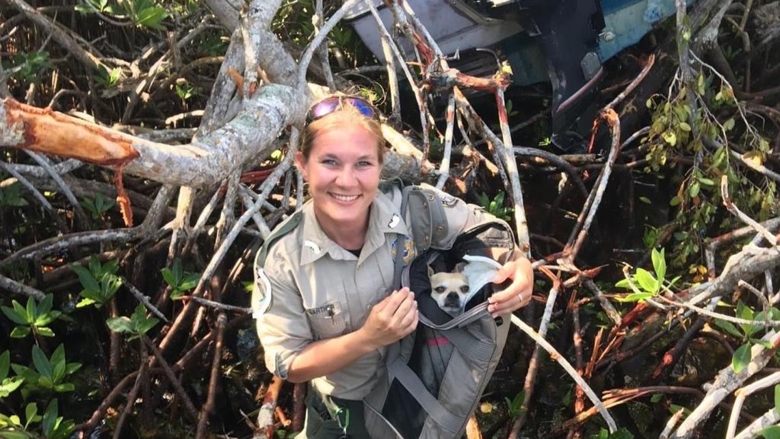 An FWC officer holds Robo, a dog rescued after his owner was taken to shore after a boat wreck.