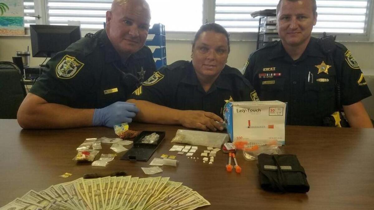 Monroe County Sheriff’s Deputy Jon Riggs, Sgt. Linda Mixon and Deputy Josh Gordon pose with cash and drugs they said was found in a suspect’s vehicle.
