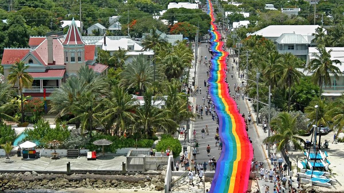 On June 15, 2003, volunteers reach the Atlantic Ocean carrying a 1.25-mile-long rainbow flag down Duval Street in Key West. The mammoth banner was created by Gilbert Baker, who developed the flag symbol in 1978.