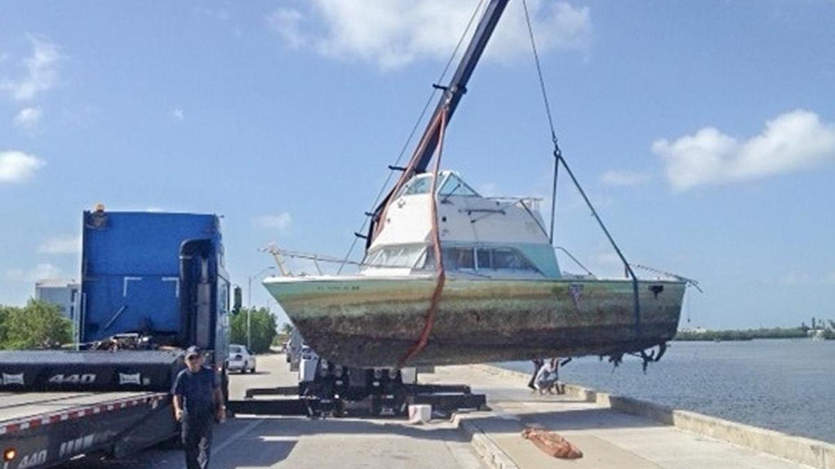 A no-longer-seaworthy boat is removed from the water.