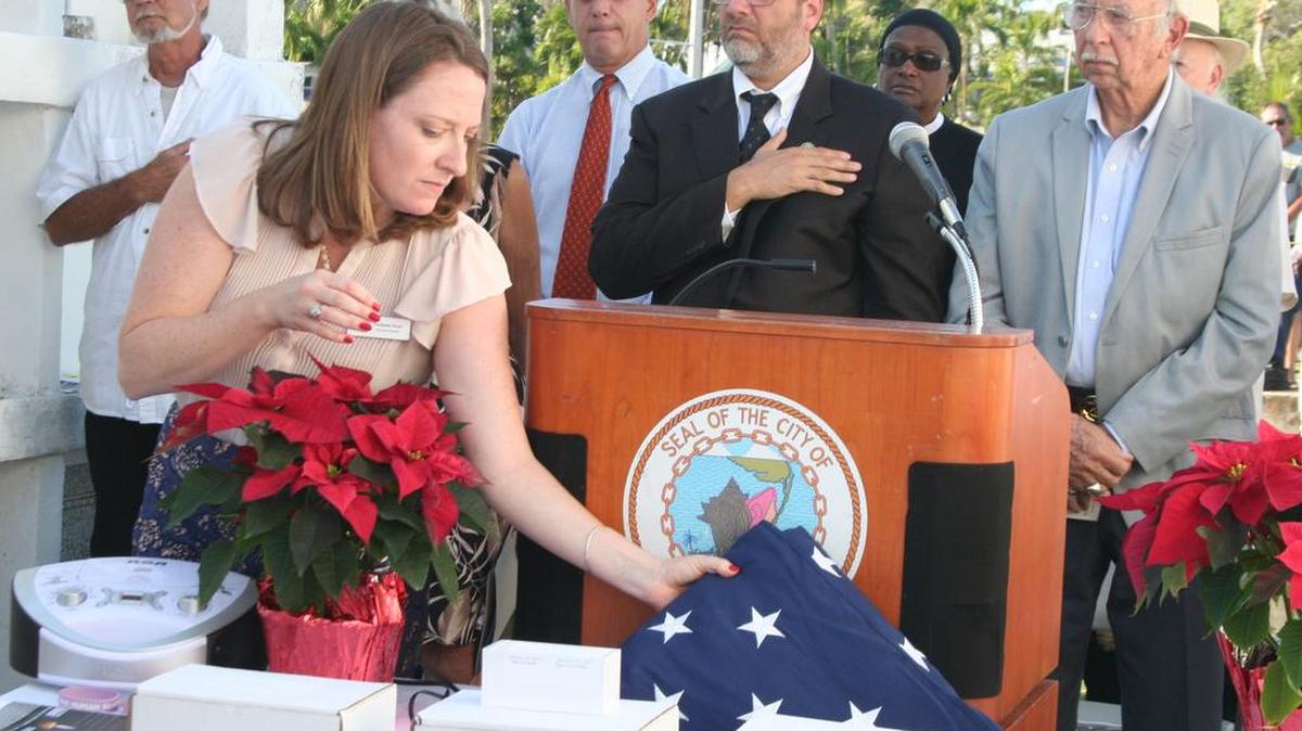 Stephanie Kaple, executive director of the Florida Keys Outreach Coalition, places the American flag beside the cremains of some of the 71 people who died this year in Monroe County without someone to claim their bodies. Nine were homeless. On Dec. 21, the coalition and Monroe County Social Services hosted a ceremony for Homeless Persons Memorial Day at the Key West Cemetery.