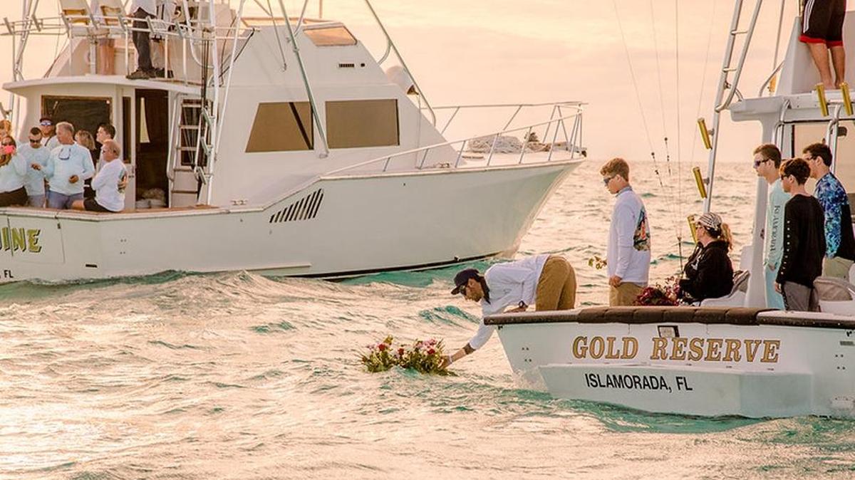 A man lays a wreath on the surface of the water at Alligator Light in memory of Holly Given, who was killed late last month by her boyfriend in Riviera Beach.