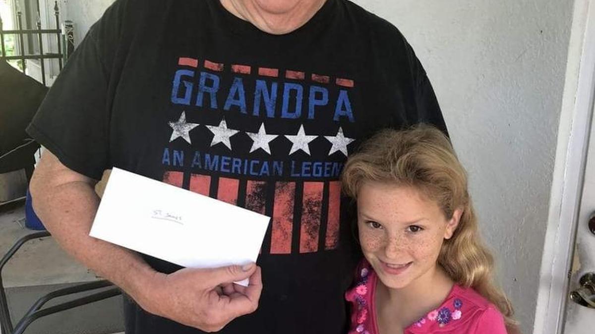 Father Thomas Graf, pastor of St. James the Fisherman Episcopal Church in Islamorada, stands with Lily, 8, who was visiting the Keys from Stuart with her family. Lily sells baked goods through her Facebook page, Boot’s Beach Bakery, and presented Graf $800 she raised to help St. James after Hurricane Irma.