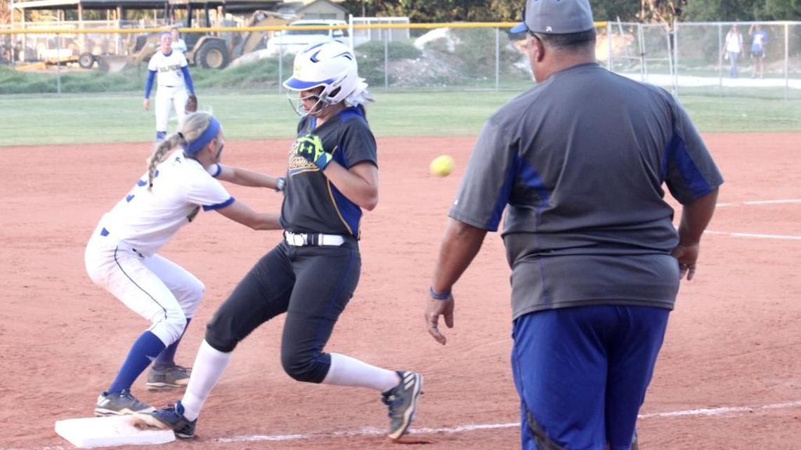 Sophomore Hannah Child catches the ball for the Lady Fins just short of Rams base runner Ashley Montoya making it back to third.