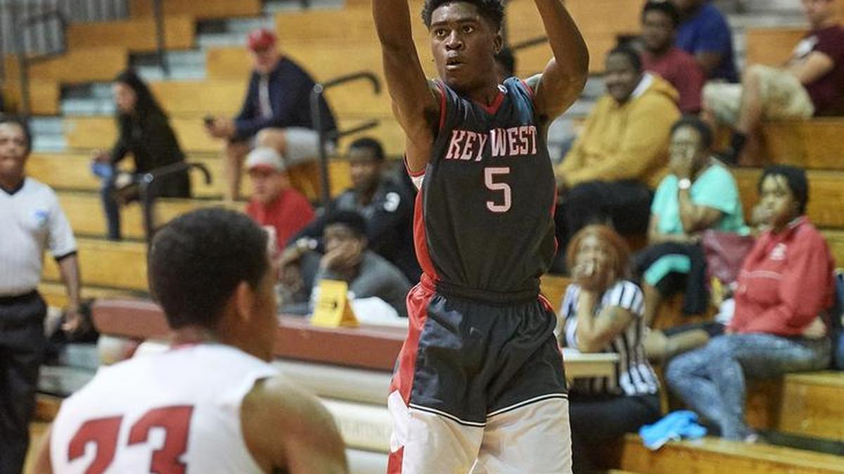 The Conchs’ Odelton Page launches a three-point shot over Evan Loesel of St. Andrew’s.
