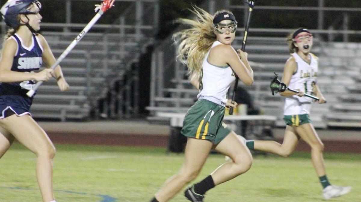 Marissa Darrow of Coral Shores High checks on her University School pursuers during an attack in the Lady Cane lacrosse win, 11-9, Friday.