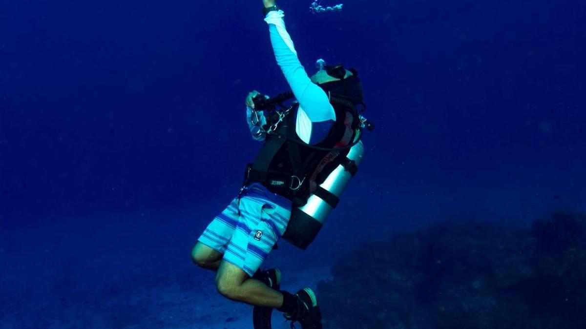 Divemaster Mario Roman Arreguin readies scuba gear in Cozumel.